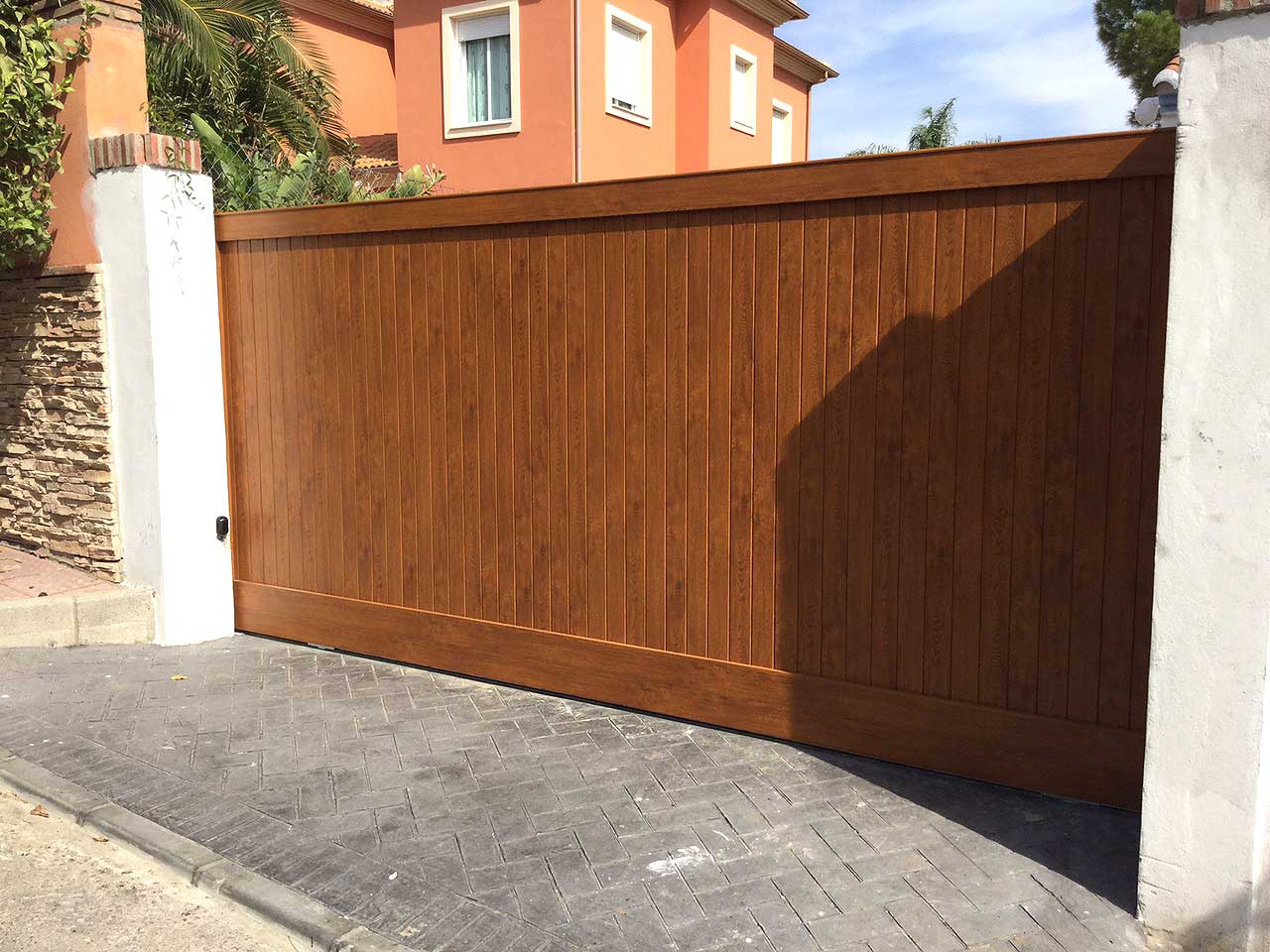 Puerta de Garaje Corredera fabricada e instalada por Gatech en Málaga. Fabricada en Aluminio con imitación a madera.